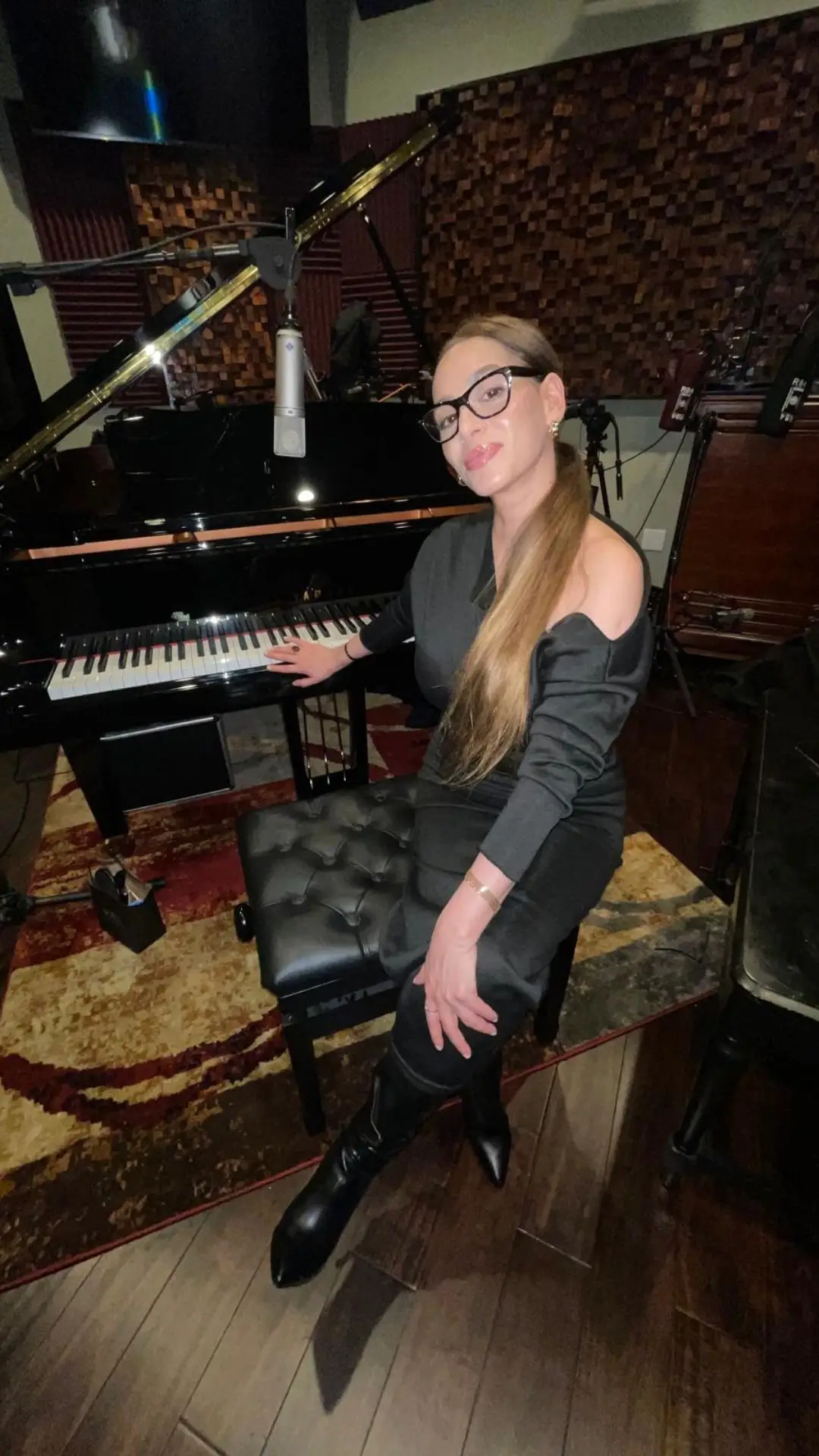 Yael James in a recording studio, wearing a dark dress.